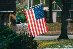 American flag hanging in a front yard: election canvassing and what you need to know