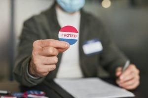 Man holding an "I Voted" sticker: how to increase voter turnout
